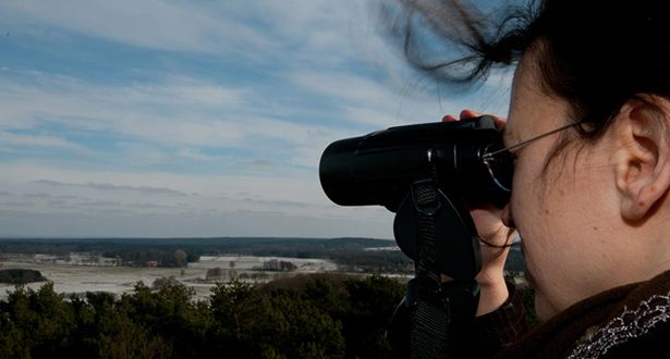 Nahaufnahme eine Frau schaut sich die Landschaft vom Paaschberg aus durch ein Fernglas an