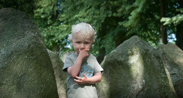 Bildausschnitt ein kleiner Junge steht in mitten einer Gruppe von Steindenkmälern