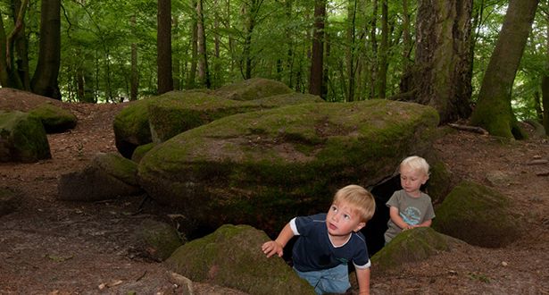 Bildausschnitt zwei kleine Jungen spielen an einem Steingrab